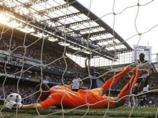Brankár Tottenhamu Heurelho Gomes zachytáva strelu Franka Lamparda na bránkovej čiare.