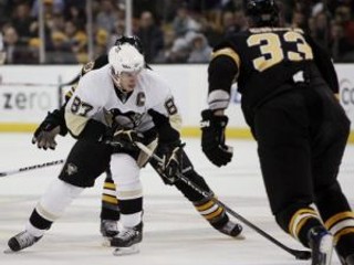 Sidney Crosby (87) z tímu Pittsburgh Penguins s pukom pred blížiacim sa slovenským obrancom mužstva Boston Bruins Zdenom Chárom.