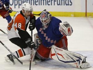 Danny Briere z Philadelphie (vľavo) zasúva puk za brankára Rangers Henrika Lundqvista.