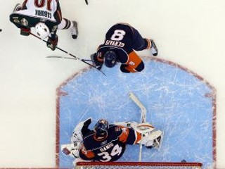 Marián Gáborík (hore v bielom) bránený Brunom Gervaisom prekonáva brankára NY Islanders Yanna Danisa.