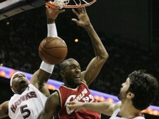 Joe Smith z Clevelandu (v červenom) zakončuje bránený dvojicou hráčov Atlanty Hawks.