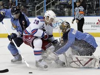 Brankár Johan Hedberg (vpravo) a Garnet Exelby (vľavo) z Atlanty zasahujú proti Fredrikovi Sjostromovi z Rangers v zápase NHL Atlanta - New York Rangers 2:3 pp.