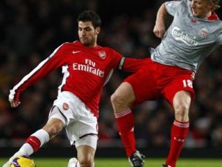 Cesc Fabregas (vľavo) atakovaný Dirkom Kuytom z Liverpoolu.