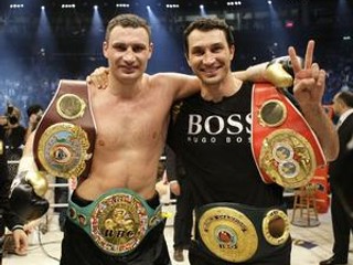 Ukrajinský boxer Vitalij Kličko (vľavo) a jeho brat Vladimir pózujú po skonče zápasu o titul majstra sveta v ťažkej váhe verzie WBC, v ktorom Vitalij porazil Nigérijčana Samuela Petera.