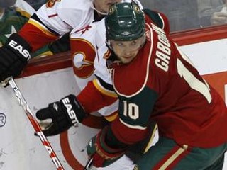 Marián Gáborík (vpravo) v súboji s Michaelom Cammallerim z Calgary.