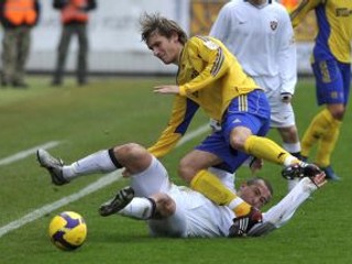 Košičan Lukáš Jančič padá cez Trnavčana Vladimíra Kožucha (na tráve).