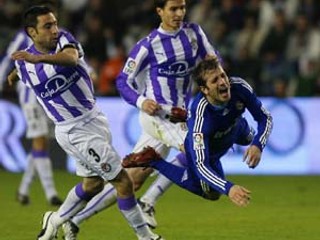Rafael van der Vaart z Realu (vpravo) padá po zákroku Reya z Valladolidu. V zápase Valladolid - Real Madrid 1:0 .
