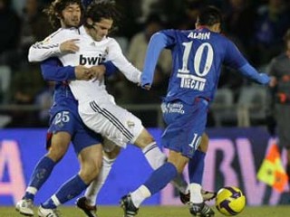 Hráč Realu Gago (v strede) sa snaží prebiť cez Albina (vpravo) a Granera.