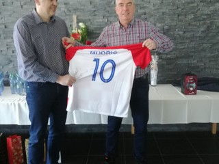 Tréner Goluža odovzdáva majiteľovi Chmeliarovi dres Modriča. 