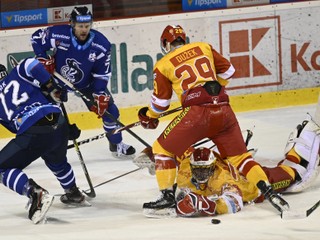 Na snímke dole brankár Dukly Matej Tomek likviduje akciu hráčov HK Poprad, vľavo Lukáš Kozák a druhý zľava Richard Huna, vpravo hore hráč Dukly Adam Dužek.