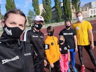 Kickboxeri pred tréningom na atletickom štadióne.