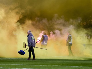 Usporiadatelia odpratávajú z ihriska pyrotechniku v zápase NAC Breda - Willem II Tilburg.