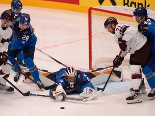 Kazakhstan's goalkeeper Andrey Shutov, center, makes a save in front of Latvia's Roberts Bukarts, second right, during the preliminary round match between Kazakhstan and Latvia at the Ice Hockey World Championships in Ostrava, Czech Republic, Tuesday, May 14, 2024. (AP Photo/Darko Vojinovic)