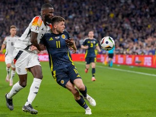 Germany's Antonio Rudiger, left, duels for the ball with Scotland's Ryan Christie during a Group A match between Germany and Scotland at the Euro 2024 soccer tournament in Munich, Germany, Friday, June 14, 2024. (AP Photo/Antonio Calanni)

- XEURO2024X