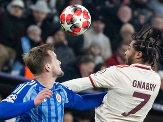 Serge Gnabry (Bayern) a Jurij Medveděv (Slovan)v súboji o loptu počas zápasu Ligy majstrov vo futbale Bayern Mníchov - Slovan Bratislava v Mníchove.