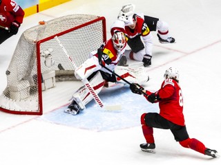 Switzerland's Christoph Bertschy, right, scores past Austria goaltender David Kickert during the ice hockey World Championship quarter final game between Switzerland and Austria, at the Jyske Bank Boxen, in Herning, Denmark, Thursday, May 22, 2025. (Salvatore Di Nolfi/Keystone via AP)