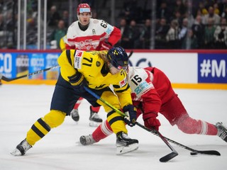 Sweden's William Karlsson, left, and Denmark's Matias Lassen fight for the puck during the bronze medal match between Denmark and Sweden at the ice hockey world championships in Stockholm, Sweden, Sunday, May 25, 2025. (AP Photo/Petr David Josek)