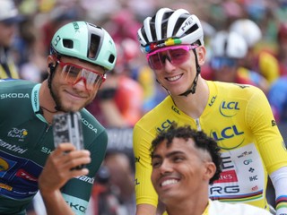 A man takes a selfie with Slovenia's Tadej Pogacar, wearing the overall leader's yellow jersey, and Italy's Jonathan Milan, wearing the best sprinter's green jersey, prior to the start of the fourteenth stage of the Tour de France cycling race over 182.6 kilometers (113.5 miles) with start in Pau and finish in Luchon-Superbagneres, France, Saturday, July 19, 2025. (AP Photo/Thibault Camus)