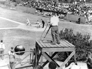 Momentka z bejzbalového zápasu, v ktorom 17. mája 1939 zdolali Princeton Tigers Columbiu Lions 2:1. Duel snímala jediná kamera na vyvýšenom drevenom pódiu a televízia NBC ho vysielala na experimentálnej stanici W2XBS.