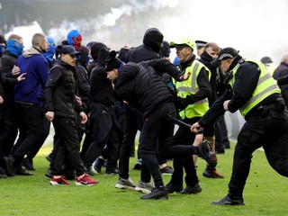 Usporiadatelia a policajti zasahujú počas bitky fanúšikov, ktorá sa strhla na ihrisku po penaltovom rozstrele po štvrťfinále Škótskeho pohára Rangers FC - Celtic Glasgow.