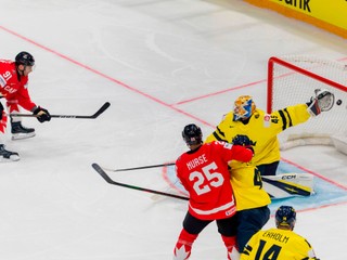 Canada's John Tavares, left, scores against Sweden goaltender Magnus Hellberg, during the 2026 IIHF Men's Ice Hockey World Championship preliminary round group B game between Canada and Sweden, at the BCF Arena ice hockey stadium, in Fribourg, Switzerland, Friday, May 15, 2026. (Salvatore Di Nolfi/Keystone via AP)