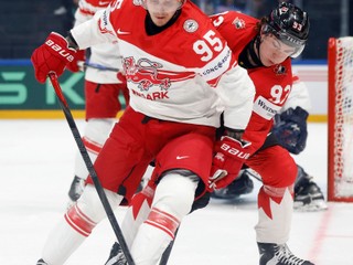 Denmark's Nick Olesen, left, vies for the puck against Canada's Fraser Minten, right, during the 2026 IIHF Men's Ice Hockey World Championship preliminary round group B game between Canada and Denmark, in Fribourg, Switzerland, Monday, May 18, 2026. (Peter Klaunzer/Keystone via AP)