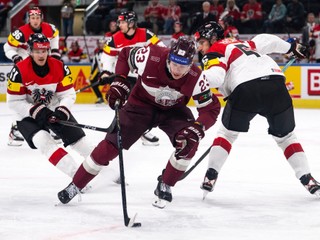 Latvia's Sandis Vilmanis is challenged by Austria's Simeon Schwinger, left, and Dominic Hackl during the Men's Ice Hockey World Championship preliminary round game between Latvia and Austria, in Zurich, Switzerland, Tuesday May 19, 2026. (Andreas Becker/Keystone via AP)