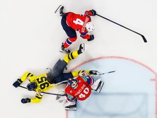 Sweden's Jacob de la Rose lies on the ice, as he tries to get hold of the puck between Norway's goaltender Henrik Haukeland, bottom, and Norway's Johannes Johannesen, top, during the 2026 IIHF Men's Ice Hockey World Championship preliminary round group B game between Norway and Sweden, at the BCF Arena ice hockey stadium, in Fribourg, Switzerland, Saturday, May 23, 2026. (Alessandro della Valle/Keystone via AP)