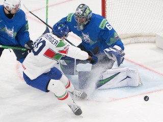 Italy's Peter Spornberger, centre, vies for the puck against Slovenia's goaltender Lukas Horak, right, during the 2026 IIHF Men's Ice Hockey World Championship preliminary round group B game between Slovenia and Italy, in Fribourg, Switzerland, Monday, May 25, 2026. (Peter Schneider/Keystone via AP)
