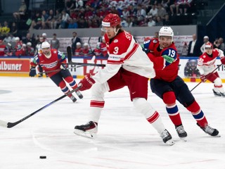 Denmark's Malte Setkov, left, and Norway's Havard Ostrem Salsten, right, fight for the puck during the 2026 IIHF Men's Ice Hockey World Championship preliminary round group B game between Norway and Denmark, in Fribourg, Switzerland, Tuesday, May 26, 2026. (Anthony Anex/Keystone via AP)