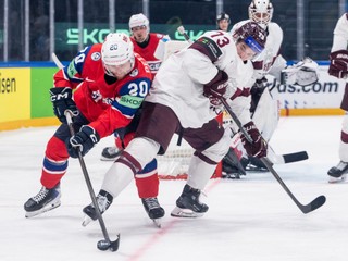 Norway's Emilio Pettersen, left, and Latvia's Deniss Smirnovs, right, challenge for the puck during the 2026 IIHF Men's Ice Hockey World Championship quarter-final match between Norway and Latvia in Fribourg, Switzerland, Thursday, May 28, 2026. (Alessandro della Valle/Keystone via AP)