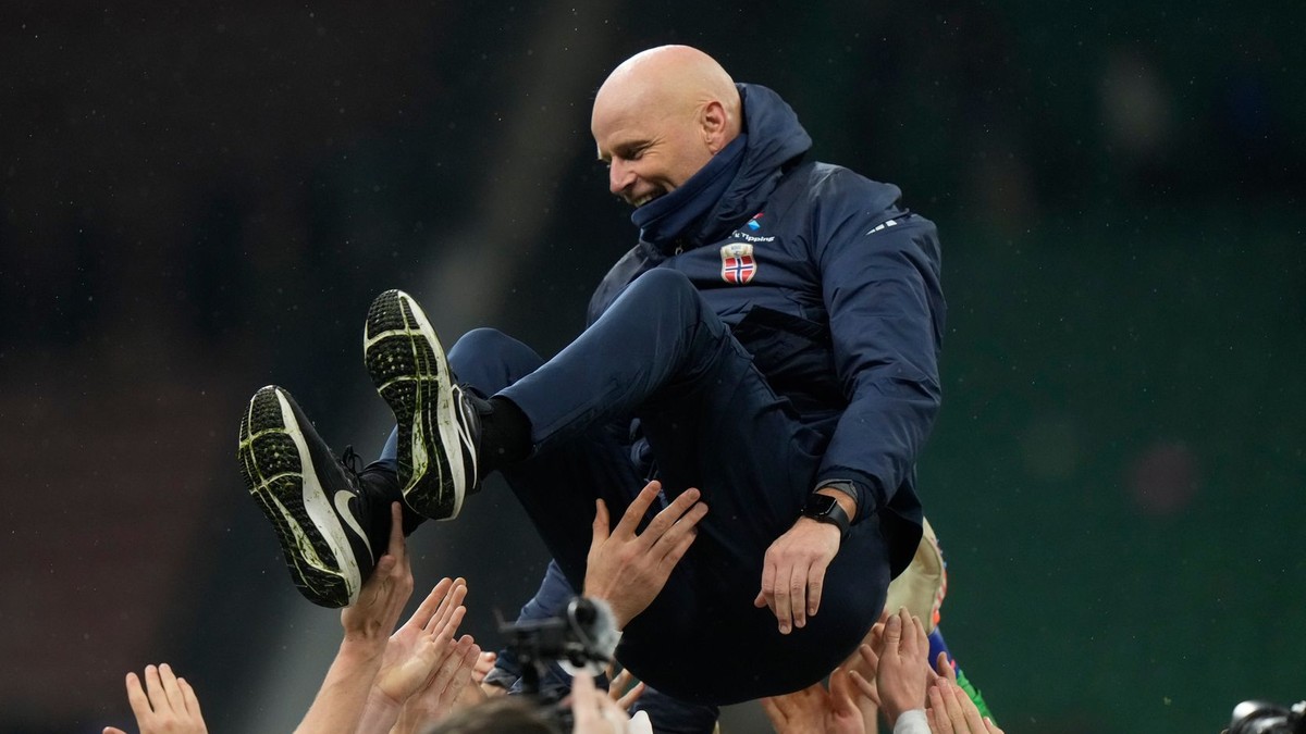 Nórski futbalisti vyhadzujú nad hlavy trénera Staaleho Solbakkena po postupe na MS 2026. 