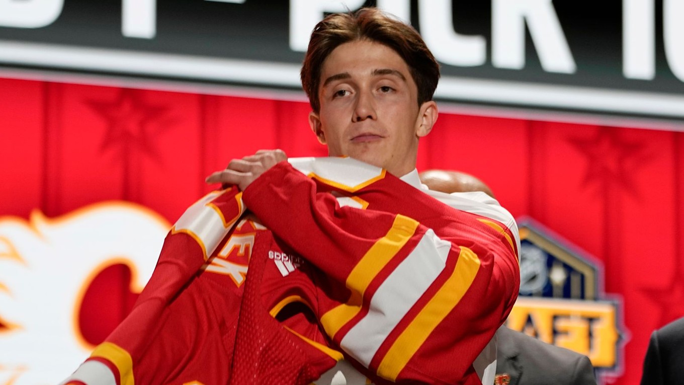 Samuel Honzek si oblieka dres Calgary Flames vo vstupnom drafte NHL 2023. 