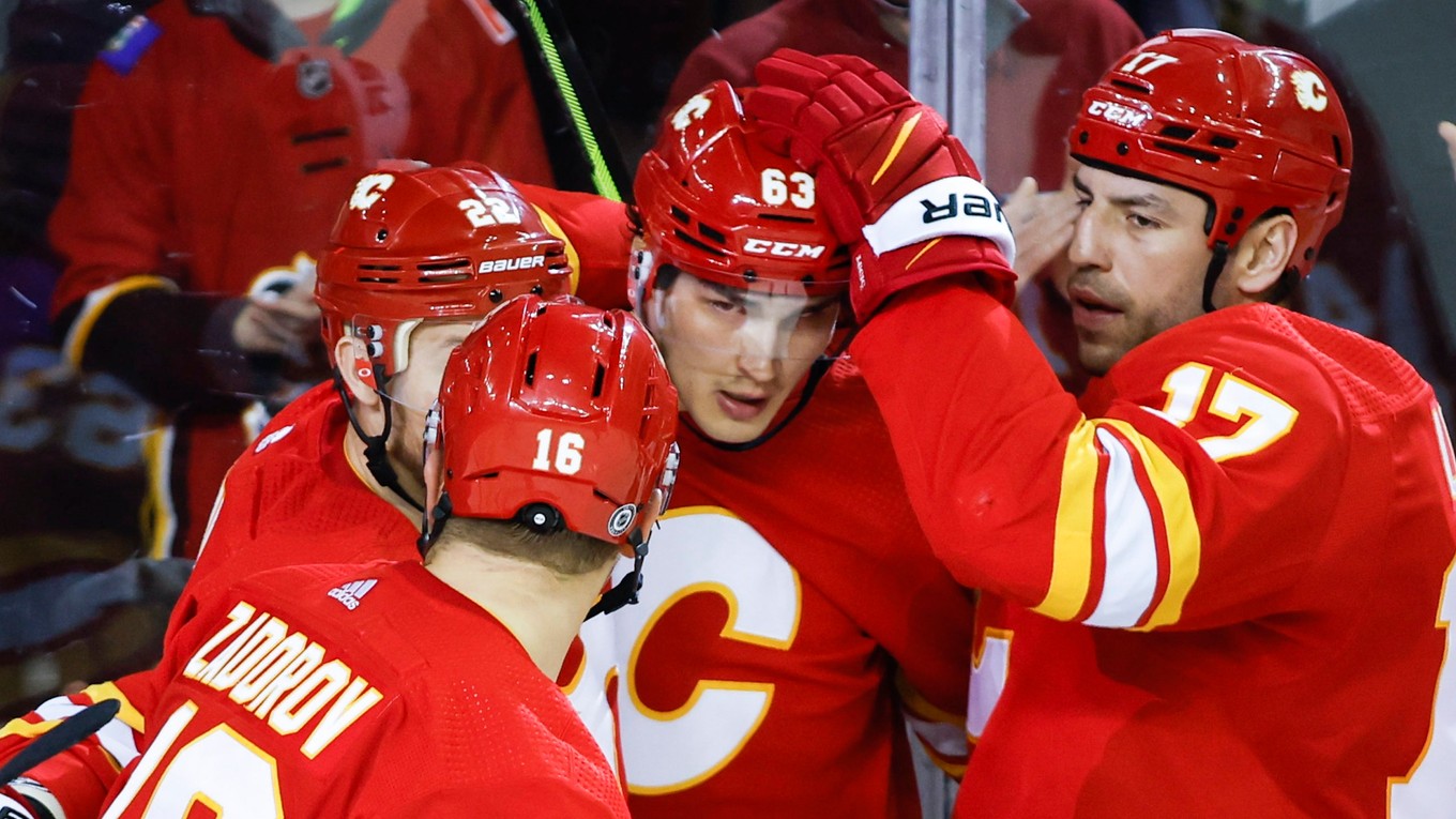 Adam Ružička oslavuje gól so spoluhráčmi v drese Calgary Flames.