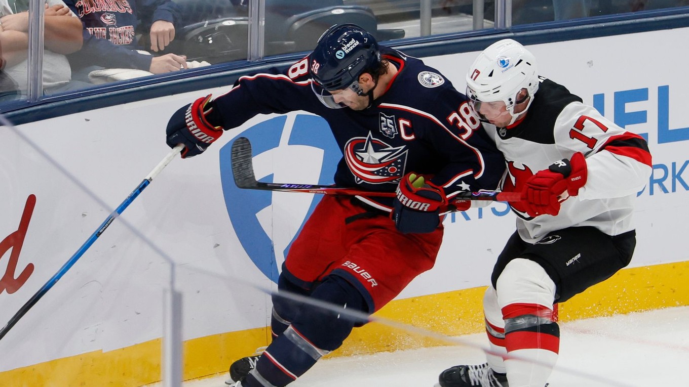 Slovenský hokejista New Jersey Devils Šimon Nemec (vpravo) a hráč Columbusu Blue Jackets Boone Jenner bojujú o puk 