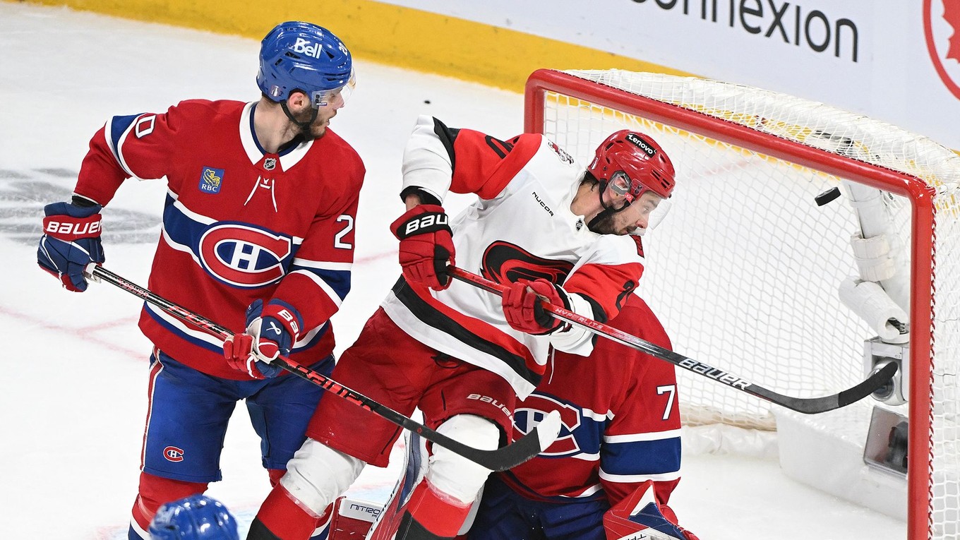 Juraj Slafkovský a Sebastian Aho pred brankárom Jakubom Dobešom pri rozhodujúcom góle v predĺžení v zápase Montreal Canadens - Carolina Hurricanes.