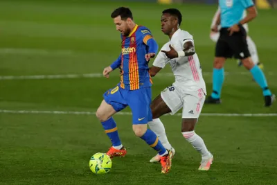 Lionel Messi (vľavo) v súboji s Viníciusom Júniorom.