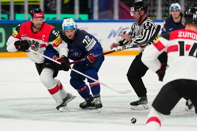 Austria's Thomas Raffl, left, and France's Jordann Perret battle for the puck during the group A match between France and Austria at the ice hockey world championship in Tampere, Finland, Saturday, May 13, 2023. (AP Photo/Pavel Golovkin)