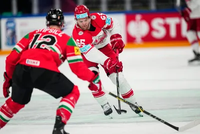 Denmark's Christian Wejse, centre, passes the puck during the group A match between Hungary and Denmark at the ice hockey world championship in Tampere, Finland, Saturday, May 13, 2023. (AP Photo/Pavel Golovkin)