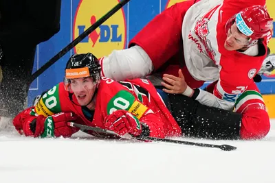Hungary's Istvan Sofron, left, and Denmark's Oliver Lauridsen battle for the puck during the group A match between Hungary and Denmark at the ice hockey world championship in Tampere, Finland, Saturday, May 13, 2023. (AP Photo/Pavel Golovkin)