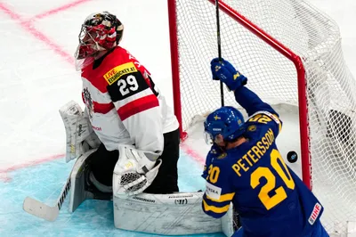 Sweden's Andre Petersson, right, celebrates after Par Lindholm scored the opening goal past Austria's goalie Bernhard Starkbaum during the group A match between Sweden and Austria at the ice hockey world championship in Tampere, Finland, Sunday, May 14, 2023. (AP Photo/Pavel Golovkin)