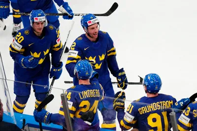 Sweden's Patrik Nemeth, centre, celebrates with teammates after scoring his side's third goal during the group A match between Sweden and Austria at the ice hockey world championship in Tampere, Finland, Sunday, May 14, 2023. (AP Photo/Pavel Golovkin)