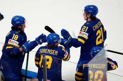 Sweden's Leo Carlsson, right, celebrates after scoring his side's fourth goal during the group A match between Sweden and Austria at the ice hockey world championship in Tampere, Finland, Sunday, May 14, 2023. (AP Photo/Pavel Golovkin)