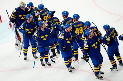 Sweden's team players celebrate as they won the group A match between Sweden and Austria at the ice hockey world championship in Tampere, Finland, Sunday, May 14, 2023. (AP Photo/Pavel Golovkin)