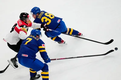 Austria's David Reinbacher, centre, battles for the puck with Sweden's Rasmus Sandin, top, and Henrik Tommernes during the group A match between Sweden and Austria at the ice hockey world championship in Tampere, Finland, Sunday, May 14, 2023. (AP Photo/Pavel Golovkin)