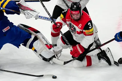 Austria's Peter Schneider battles for the puck during the group A match between Sweden and Austria at the ice hockey world championship in Tampere, Finland, Sunday, May 14, 2023. (AP Photo/Pavel Golovkin)