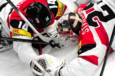 Austria's goalie Bernhard Starkbaum, right, tries to cover the puck during the group A match between Sweden and Austria at the ice hockey world championship in Tampere, Finland, Sunday, May 14, 2023. (AP Photo/Pavel Golovkin)