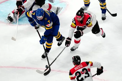 Austria's Benjamin Nissner, right, and Sweden's Henrik Tommernes battle for the puck during the group A match between Sweden and Austria at the ice hockey world championship in Tampere, Finland, Sunday, May 14, 2023. (AP Photo/Pavel Golovkin)