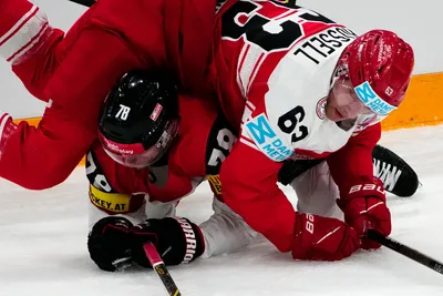 Denmark's Patrick Russell, right, and Austria's Thimo Nickl battle for the puck during the group A match between Denmark and Austria at the ice hockey world championship in Tampere, Finland, Tuesday, May 16, 2023. (AP Photo/Pavel Golovkin)