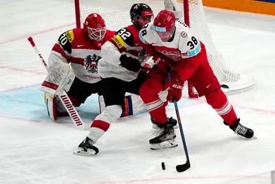 Denmark's Morten Poulsen, right, and Austria's Bernd Wolf battle for the puck during the group A match between Denmark and Austria at the ice hockey world championship in Tampere, Finland, Tuesday, May 16, 2023. (AP Photo/Pavel Golovkin)